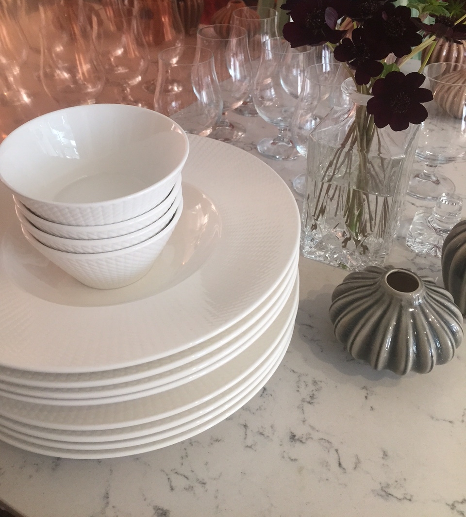 Valkoiset lautaset ja kulhot marmoripöydällä