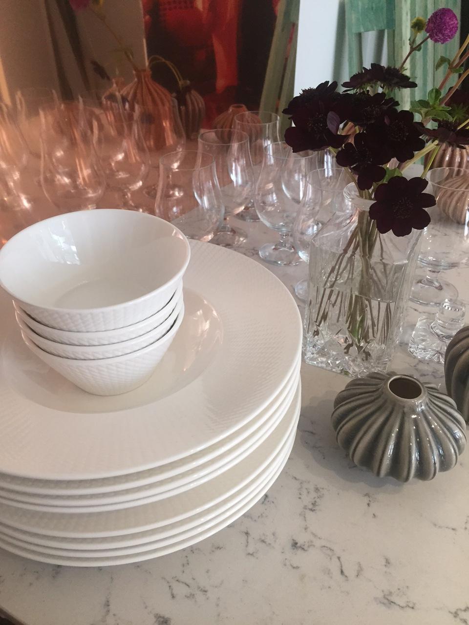 Valkoiset lautaset ja kulhot marmoripöydällä