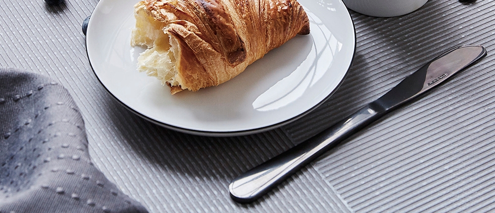 veitsi ja valkoinen lautanen pöydällä jossa voisarvi