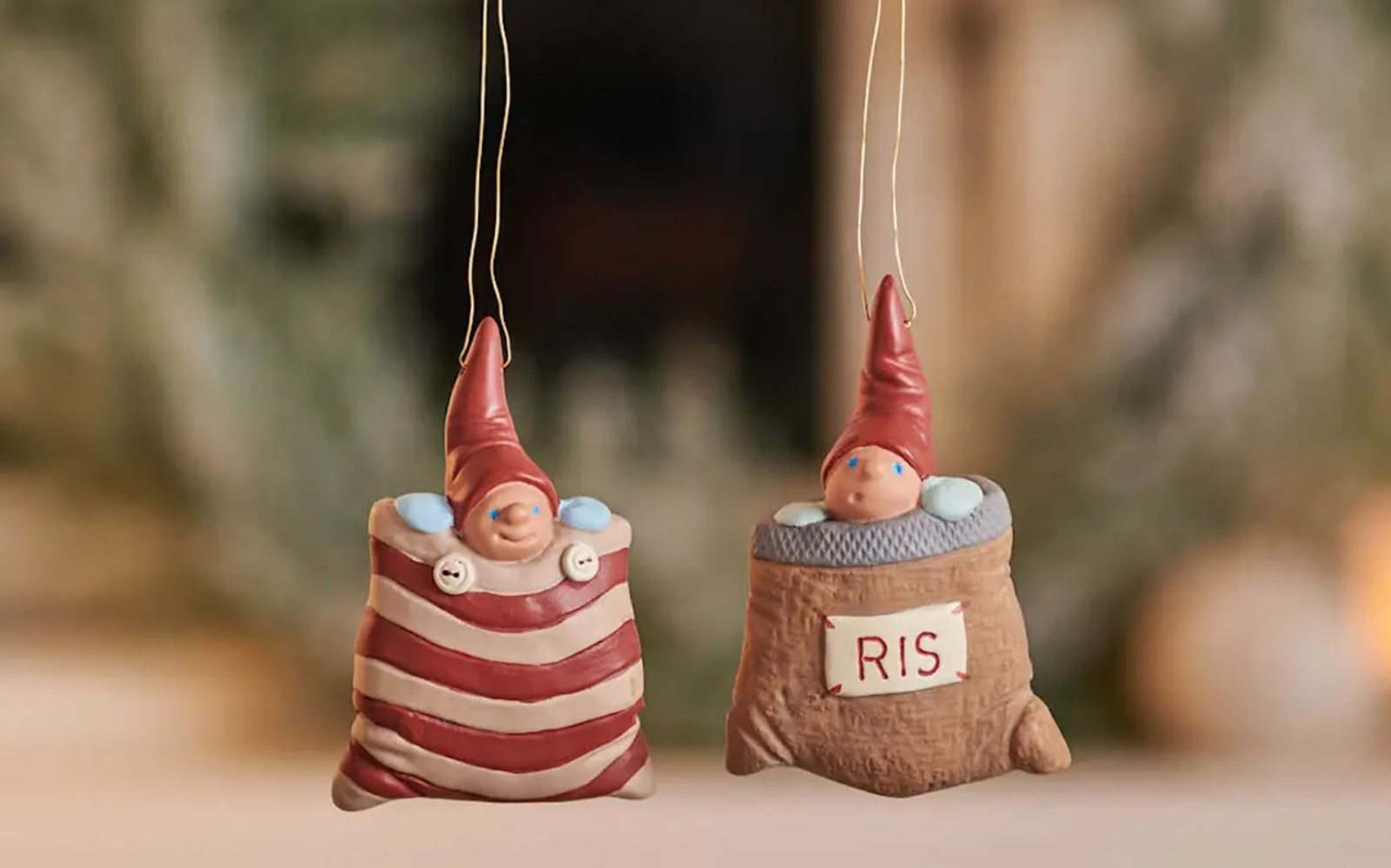 a couple of christmas ornaments hanging from a string on a table .