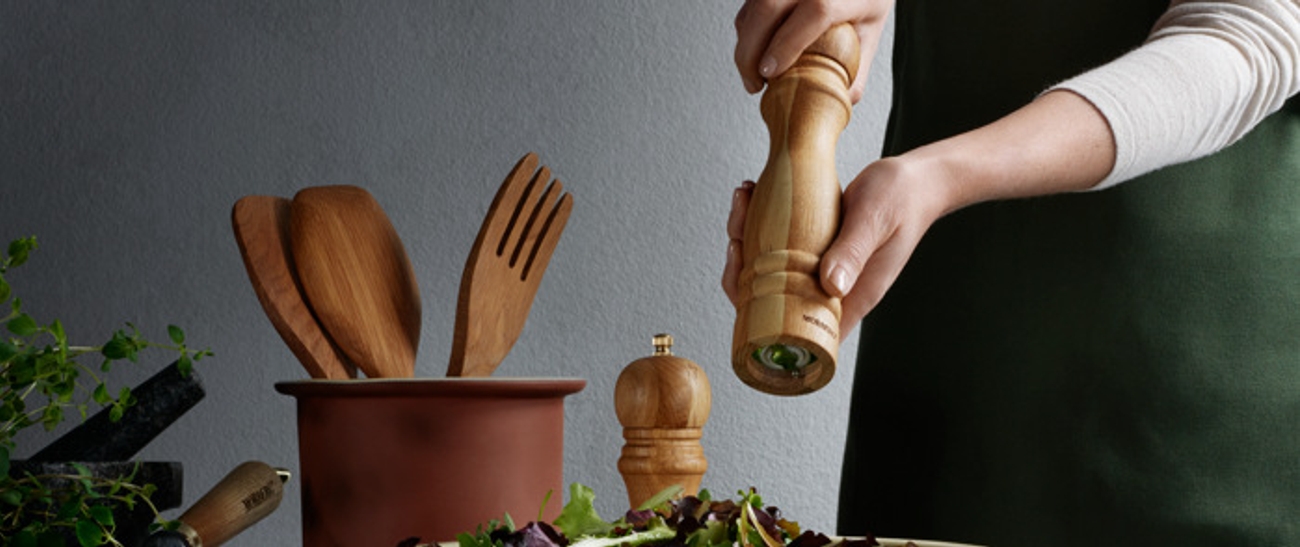 Saltkvarnar i trä som vrids över sallad 