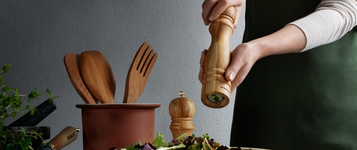 Saltkvarnar i trä som vrids över sallad