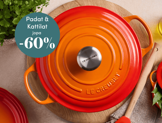 Oranssi Le Creuset valurautapata ja nuolija puisella alustalla pöydällä
