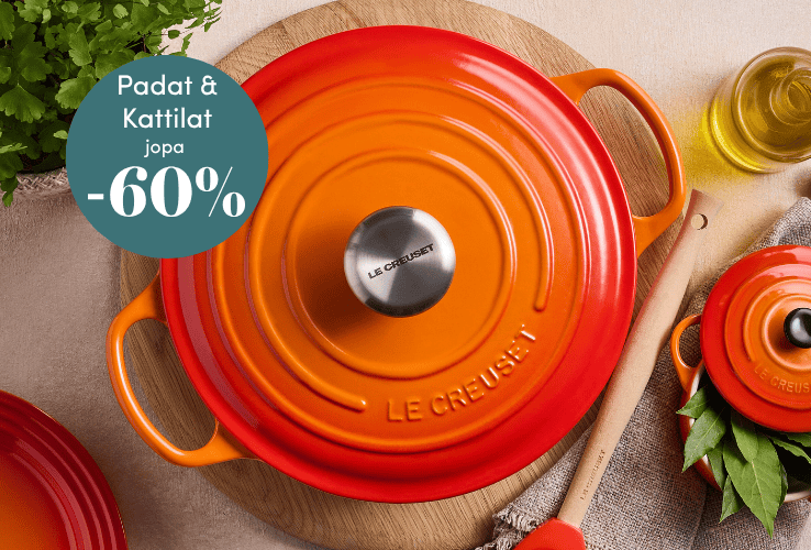 Oranssi Le Creuset valurautapata ja nuolija puisella alustalla pöydällä