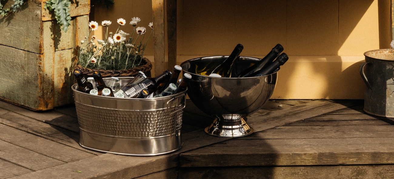 Ölhink med öl och champagnekylare med champagne på en altan utomhus