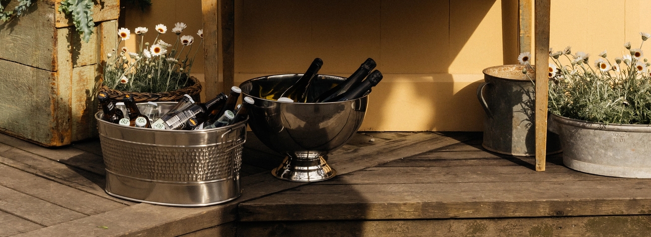 Ölhink med öl och champagnekylare med champagne på en altan utomhus