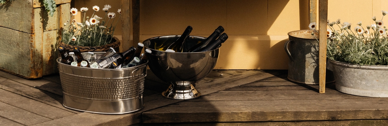 Ölhink med öl och champagnekylare med champagne på en altan utomhus