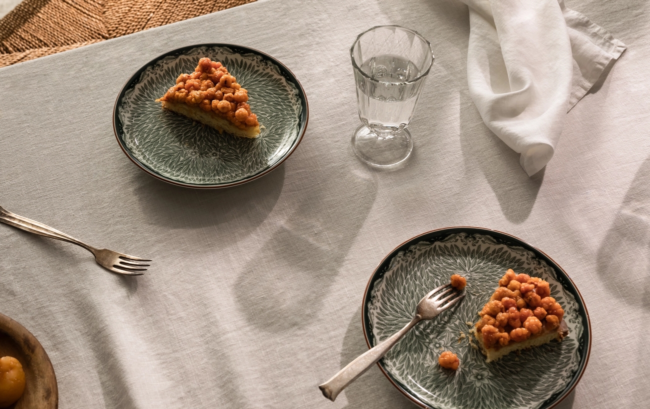 Eplepai på grønnmønstrede tallerkener stående på et bord med en beige linduk