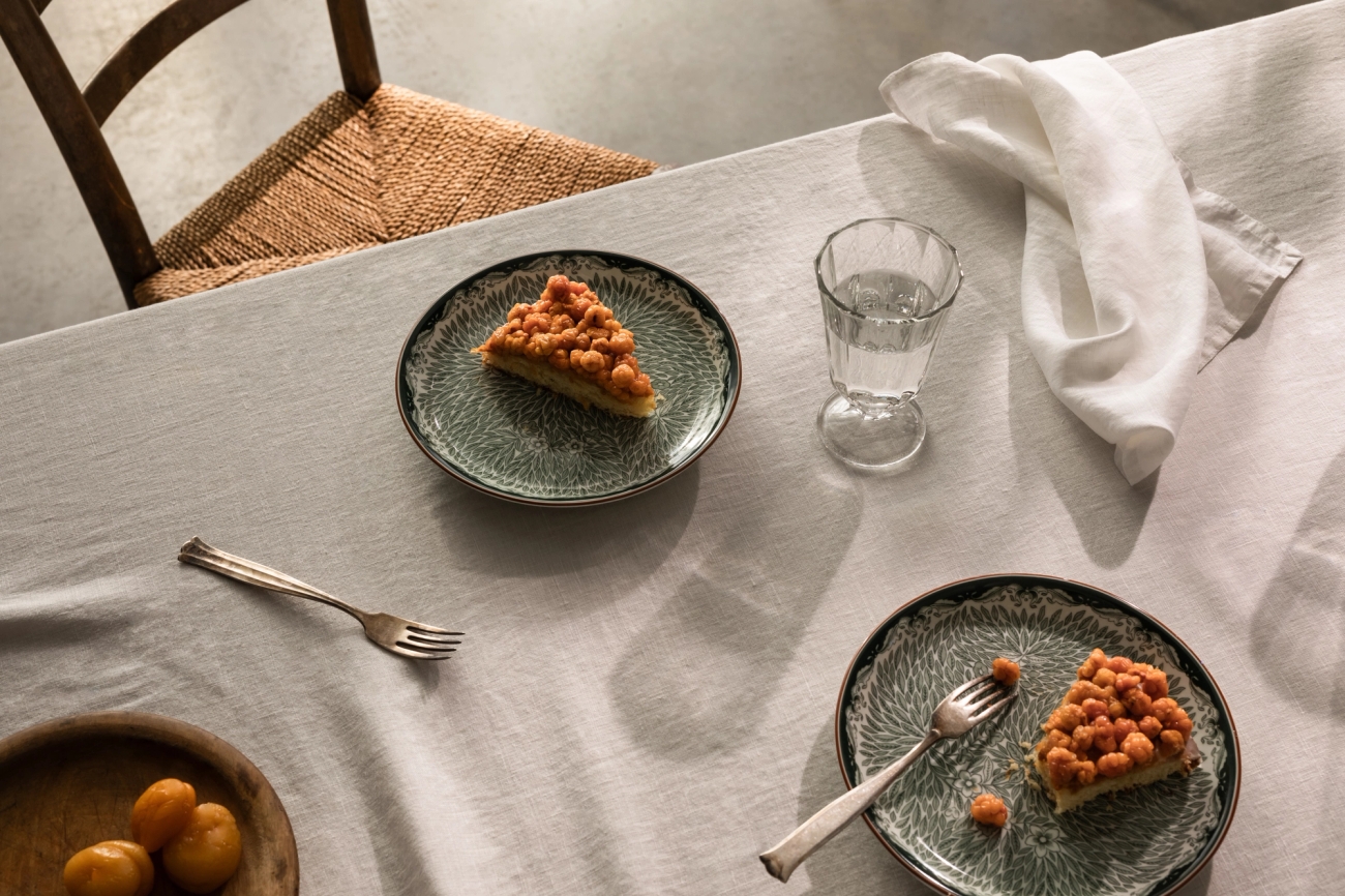 Två pajbitar på tallrikar från Ostindia grön ståendes på ett bord med en linneduk