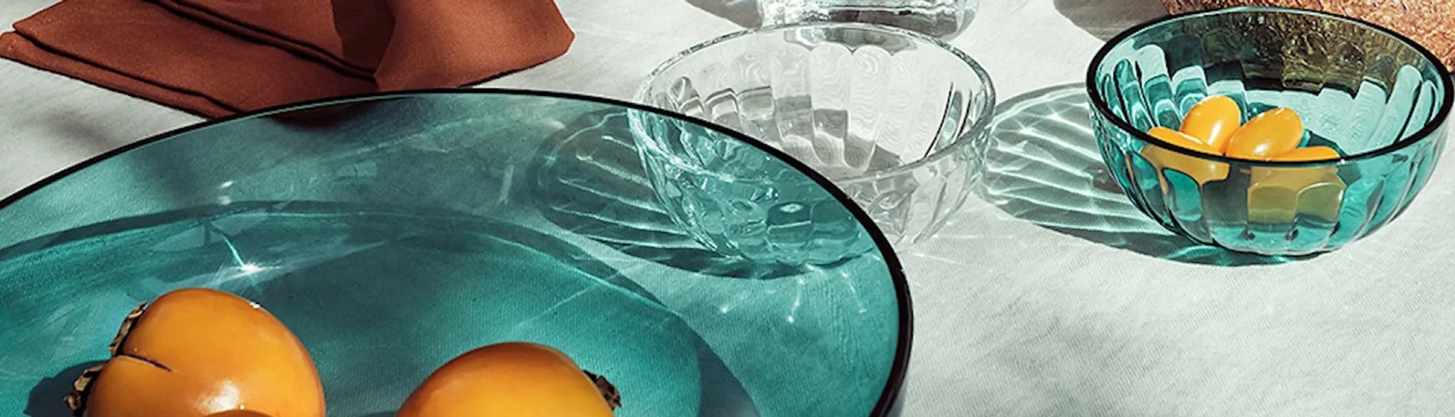 Serveringsskål & Salladsskål i genomskinligt glas i klar och blått med orangea frukter 