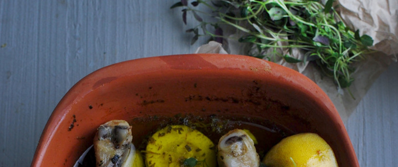 Leirgryte med poteter og kylling samt timian ved siden av