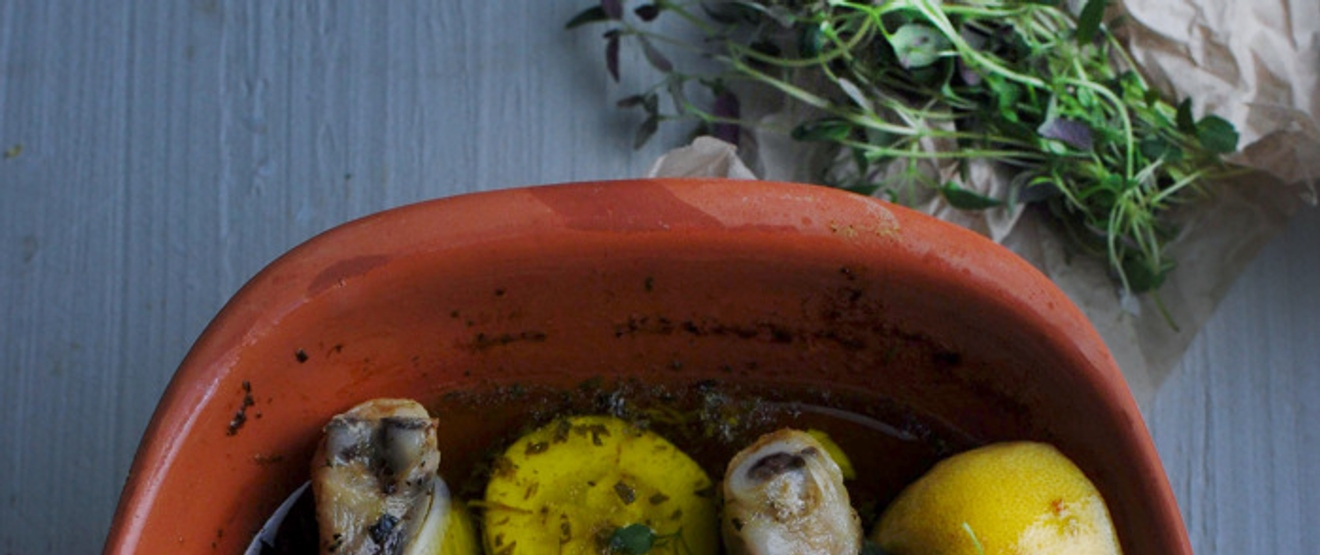 Leirgryte med poteter og kylling samt timian ved siden av