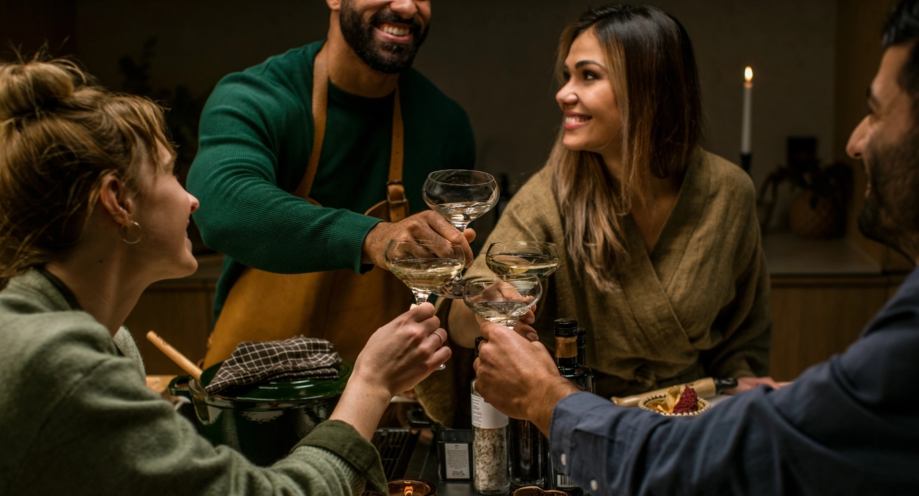 Personer som skålar med vackra glas runt ett bord