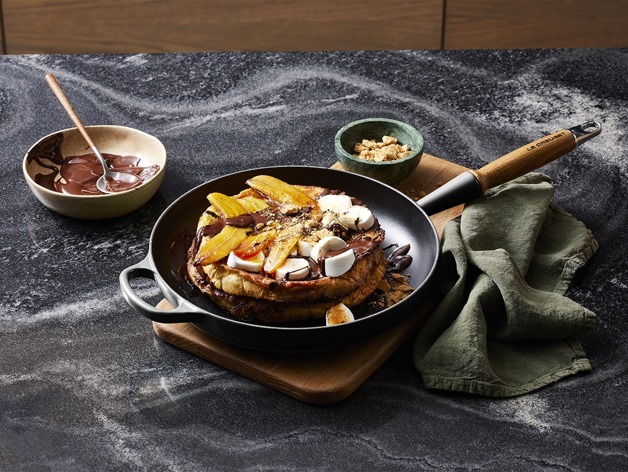 Stekpanna i gjutjärn fylld med goda stekta pannkakor