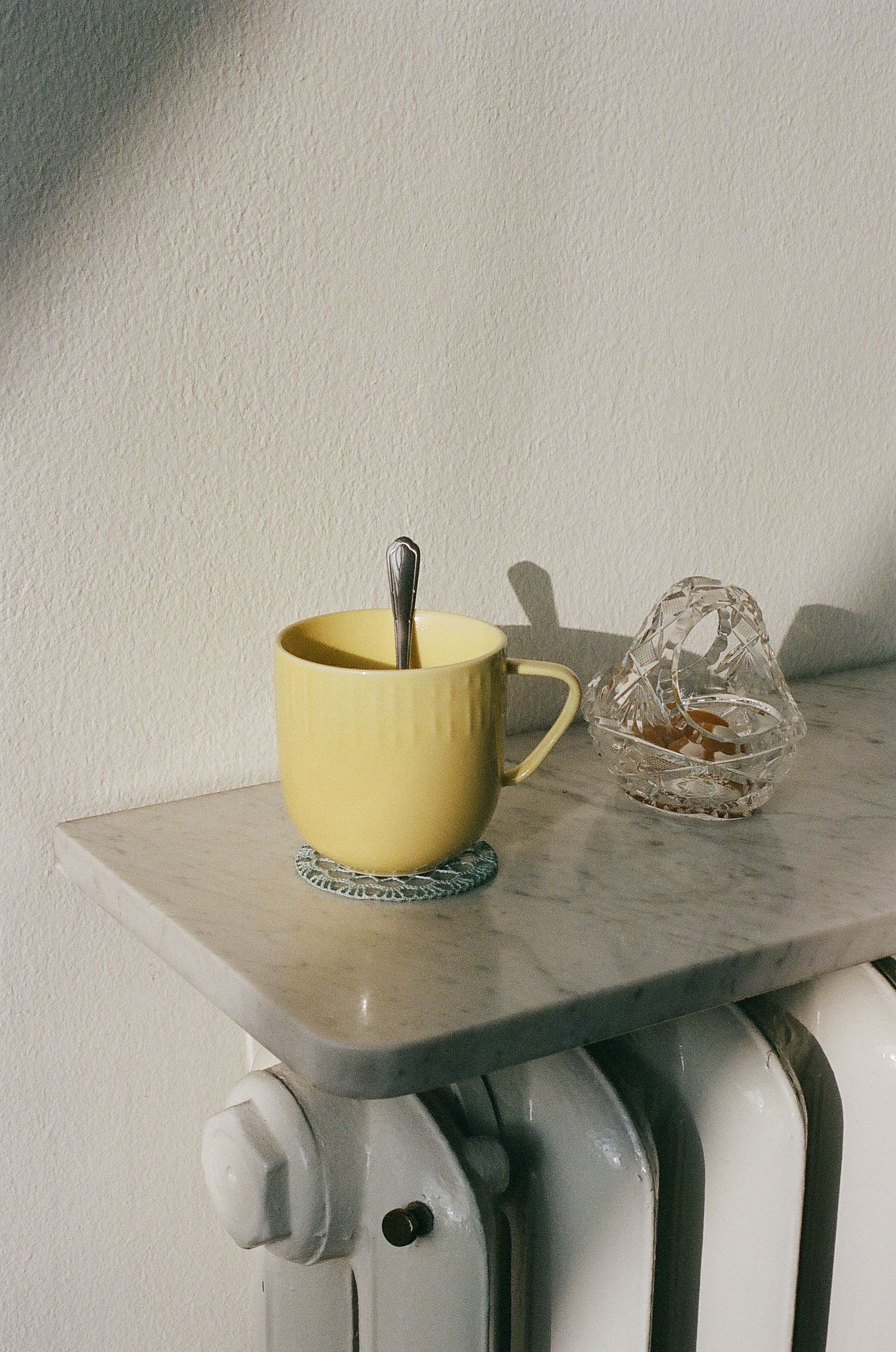 En tekopp i soljluset på en marmorskiva ovanför ett element