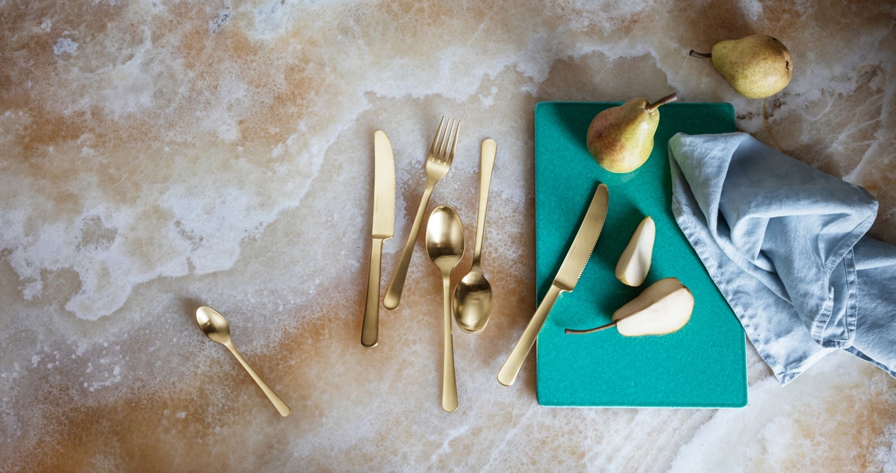 Guldbestick utspridda på marmorbänk