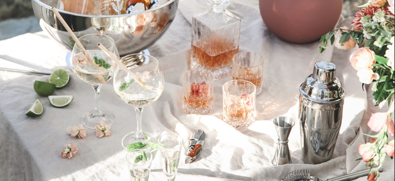Pöytä cocktaileilla ja juomatarvikkeilla sekä kevätkukkia