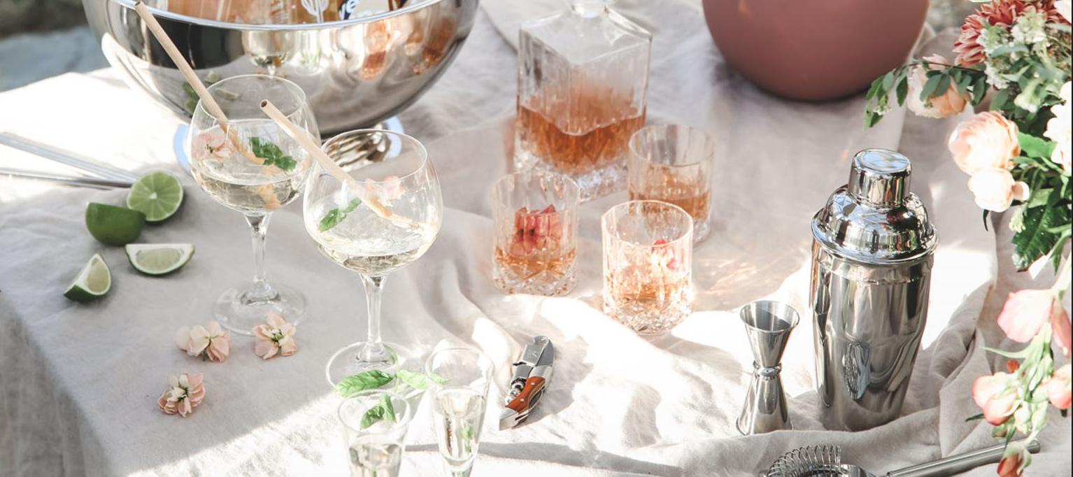 Pöytä cocktaileilla ja juomatarvikkeilla sekä kevätkukkia