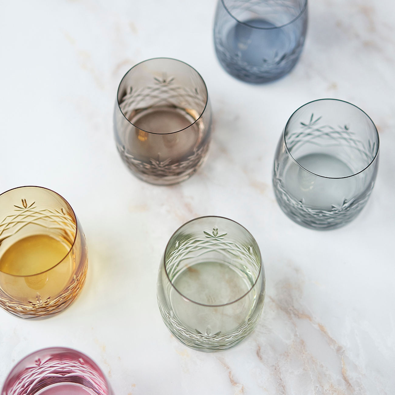 Värikkäät juomalasit väreissä keltainen vihreä ja sininen