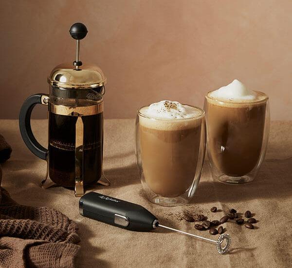 Presskanne og to glass kaffe som er toppet med skummet melk