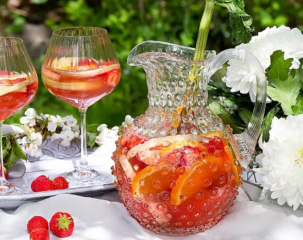 Somrig sangira med jordgubar i en glaskaraff