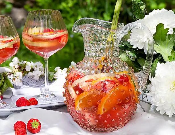 Somrig sangira med jordgubar i en glaskaraff