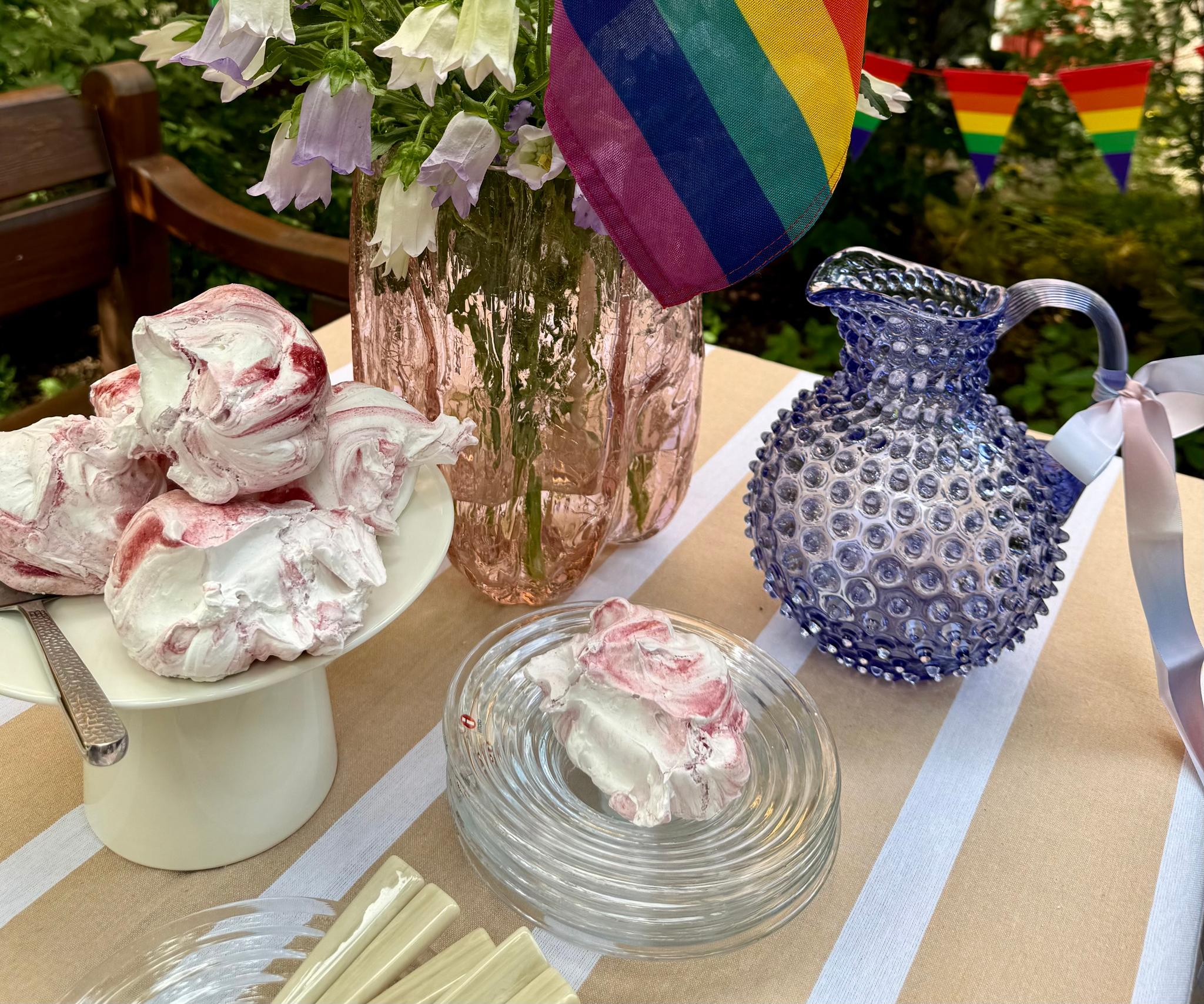 a table with a vase of flowers and a rainbow flag