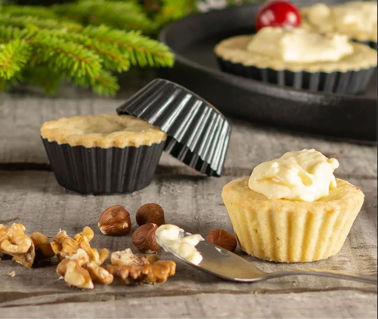 Mandelmusselformar med mandelmusslor i på en grå duk