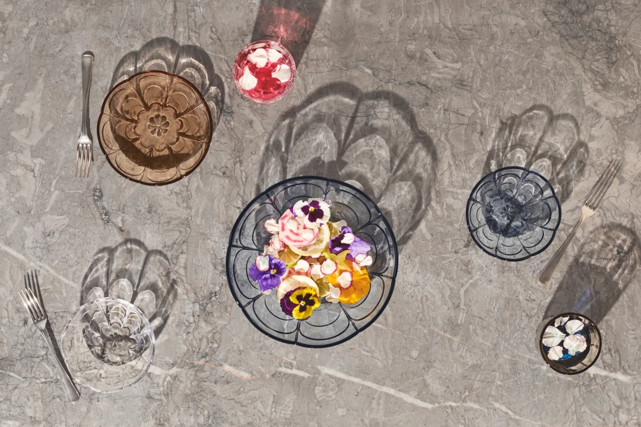 Erikokoiset lasilautaset väreissä sininen vaaleanpunainen ja kirkas koristeltu värikkäillä kukilla 