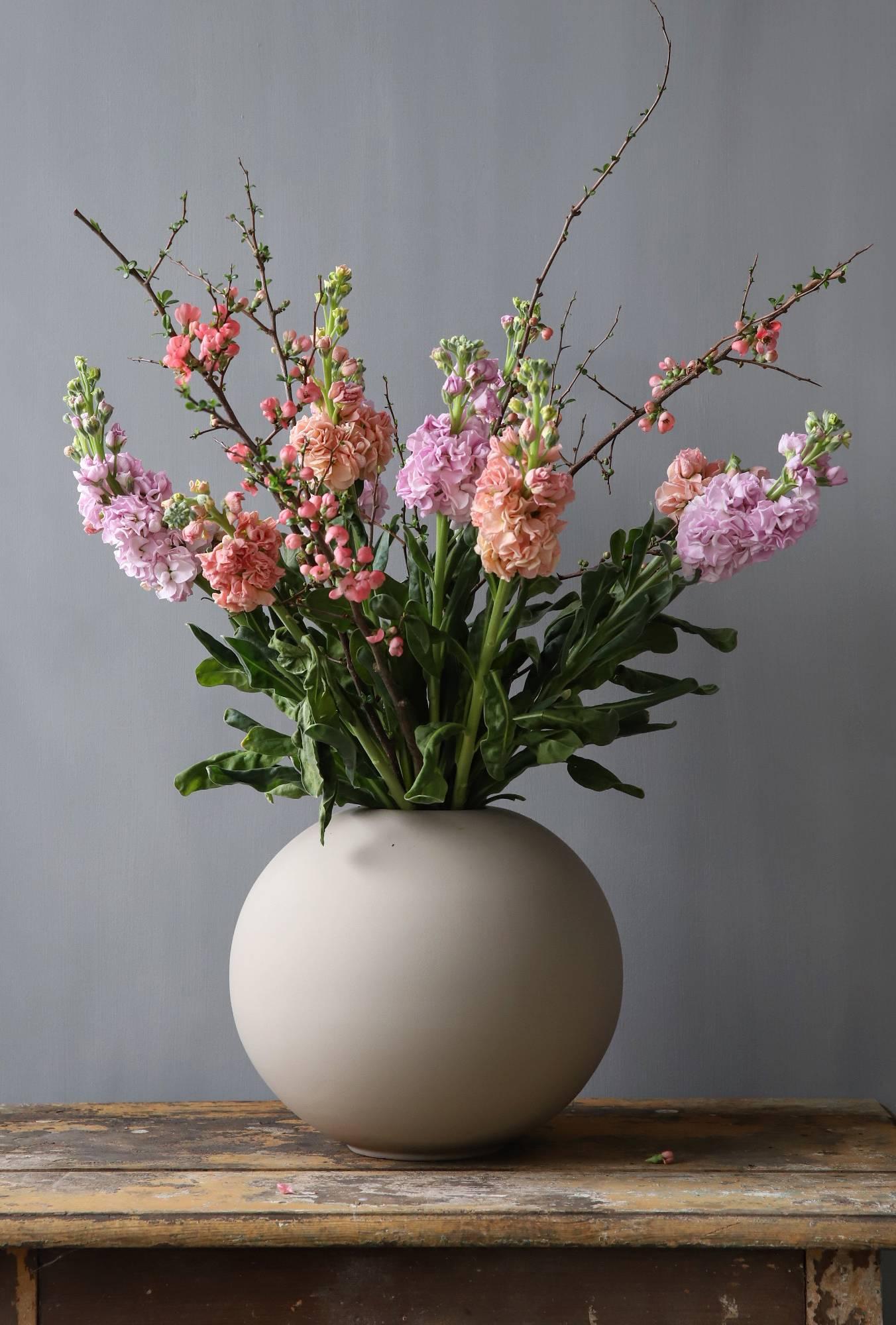 Cooee Ball Maljakko hiekan värinen värikkäät leikkokukat pöydällä