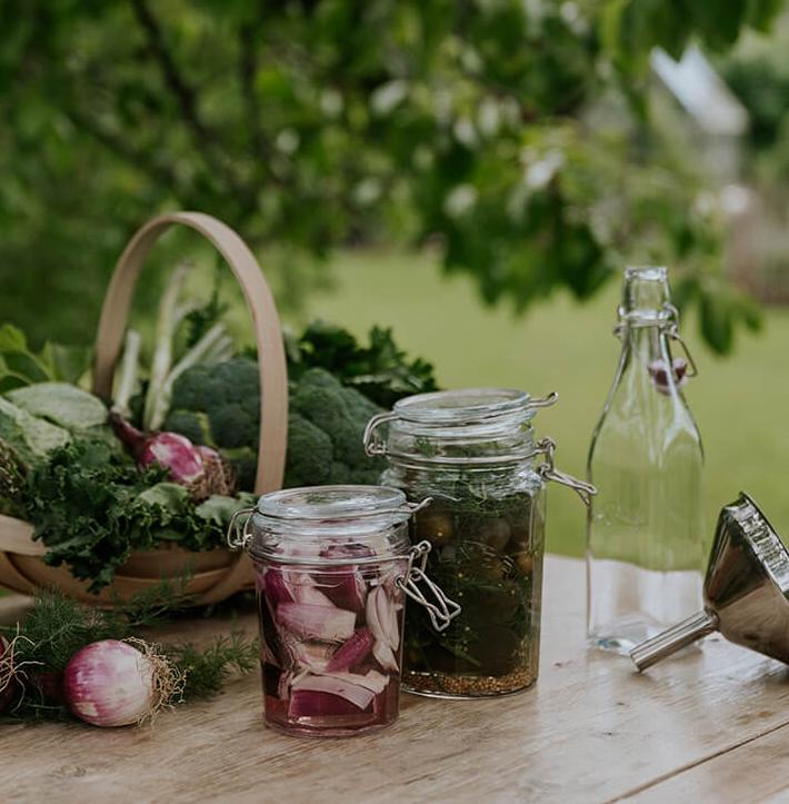 Skördade grönsaker i en korg på ett bord utomhus