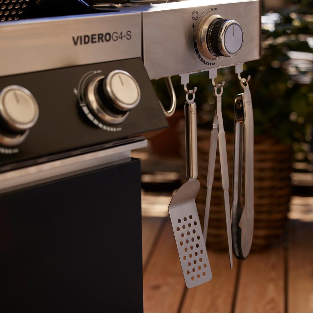 Hamburgerspade hängandes på en grill