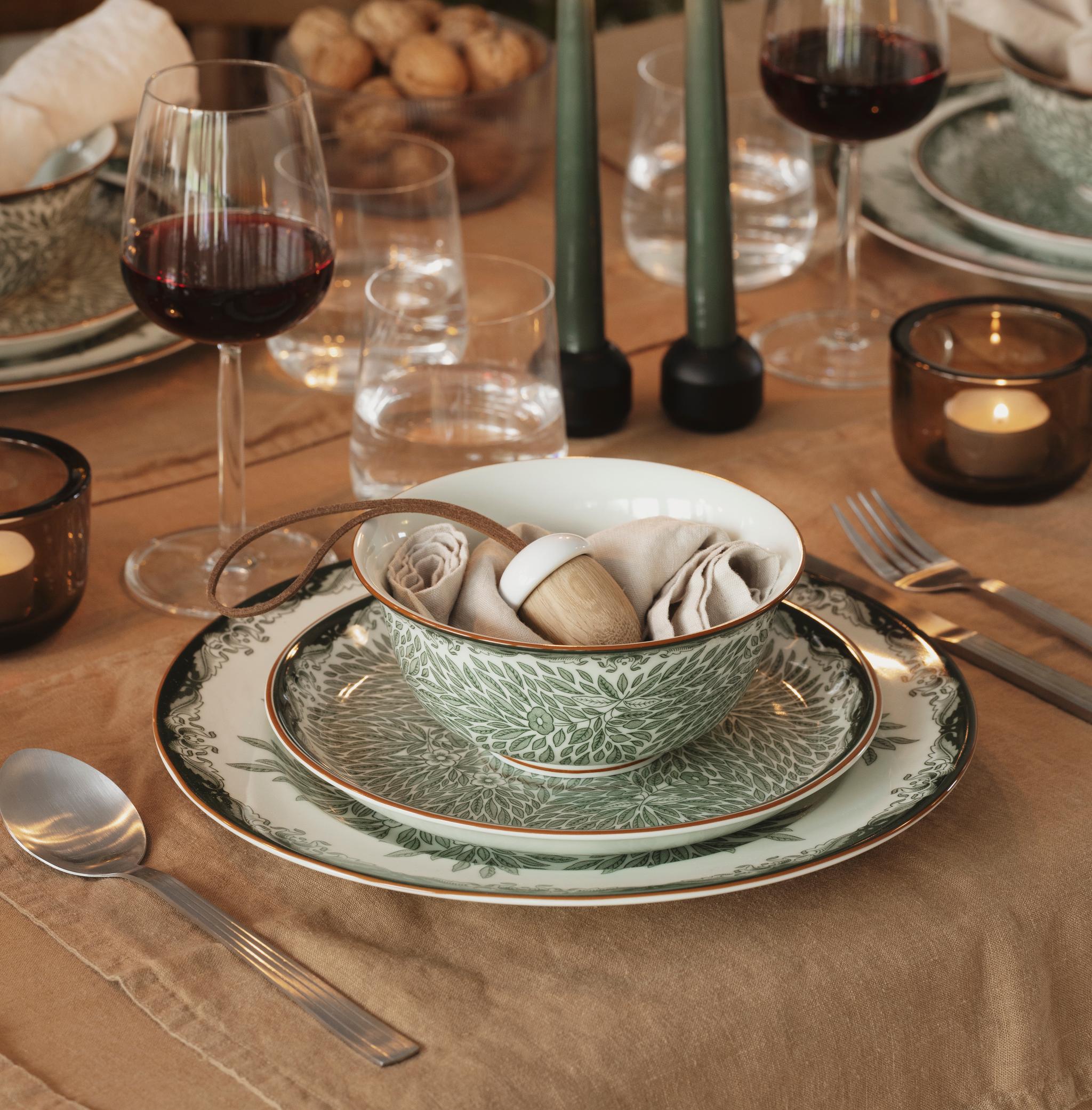 a table set with plates candles and wine glasses