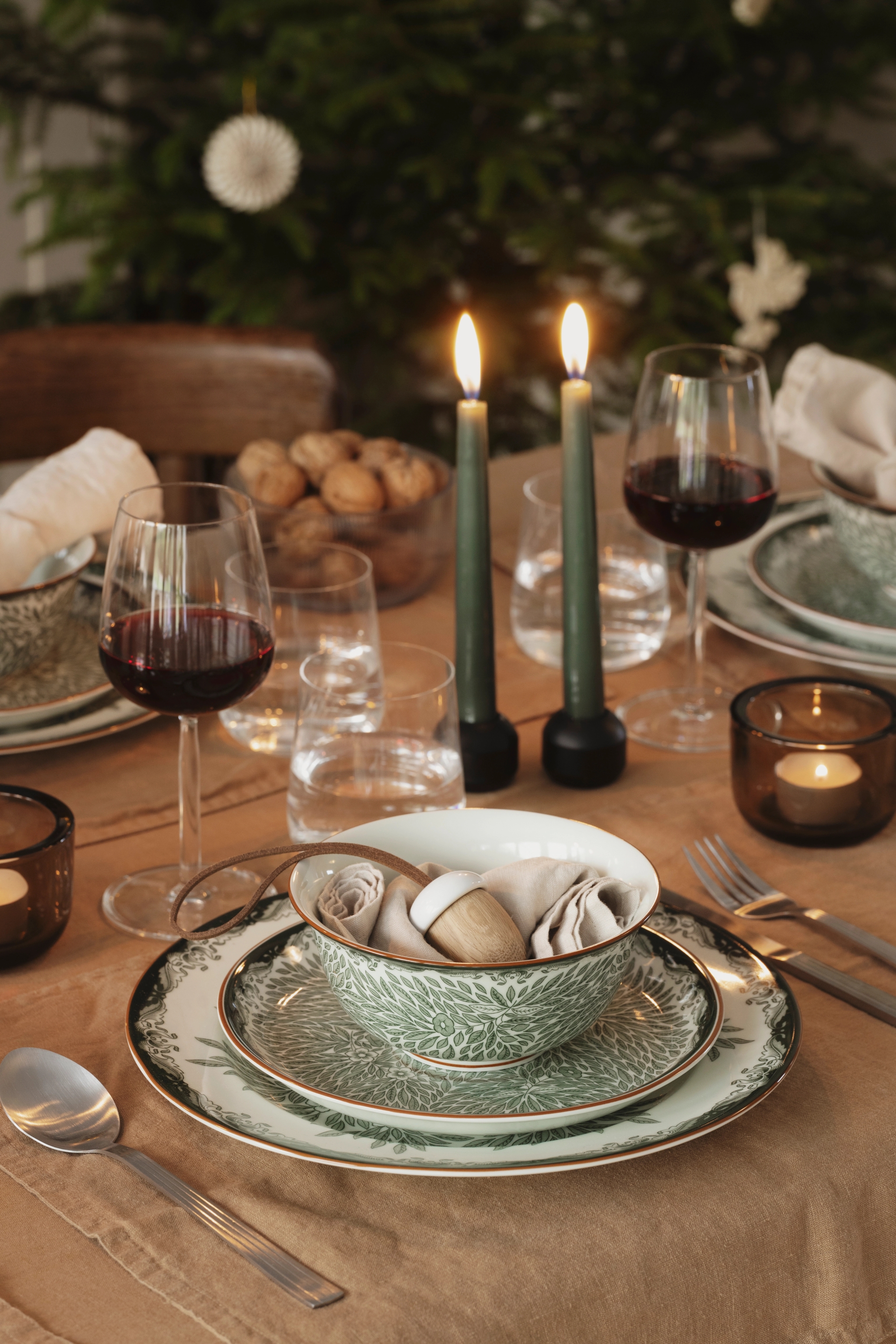 a table set with plates candles and wine glasses