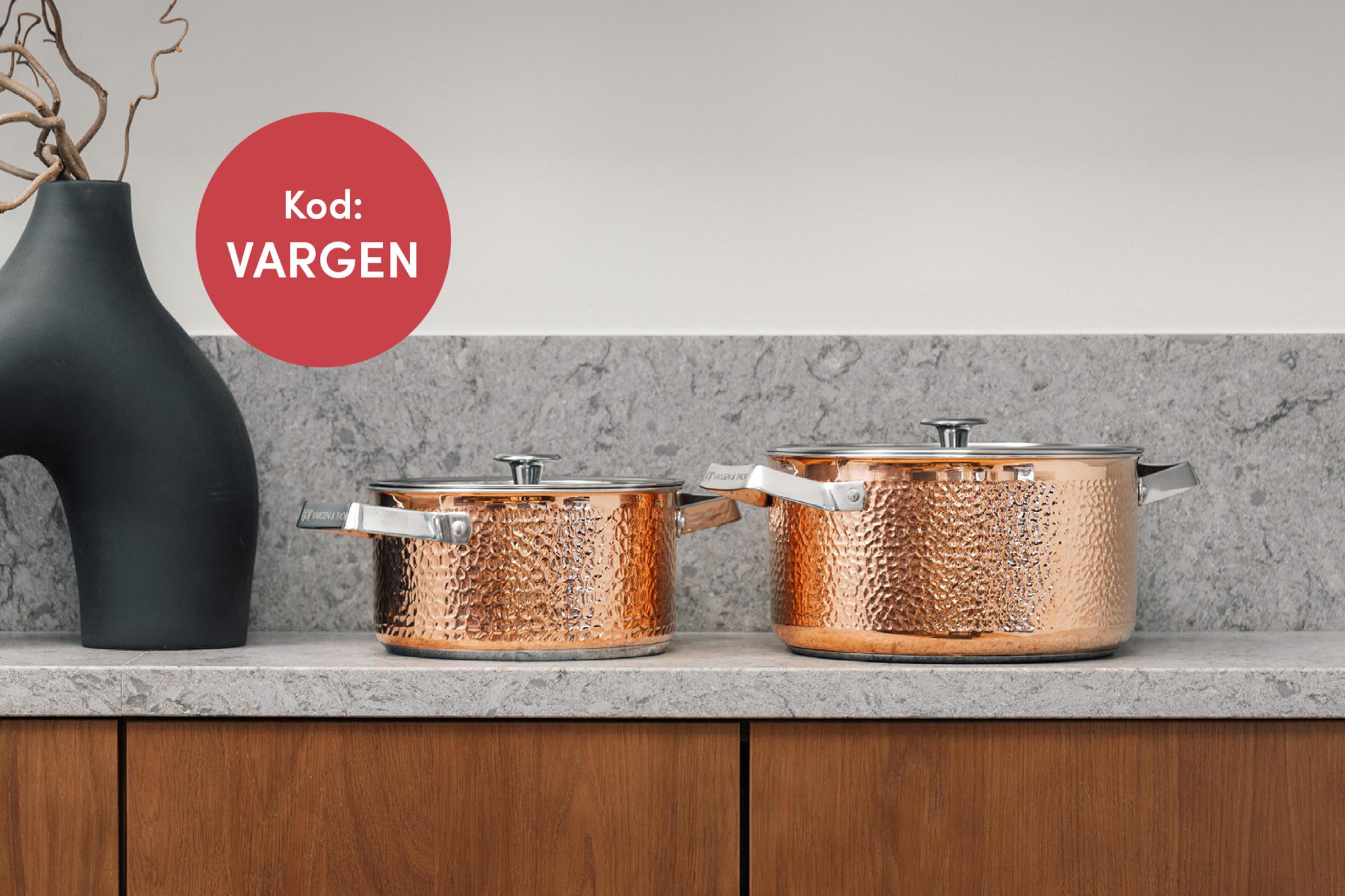 Två hamrade grytor i koppar från Vargen & Thor står på en köksbänk i marmor