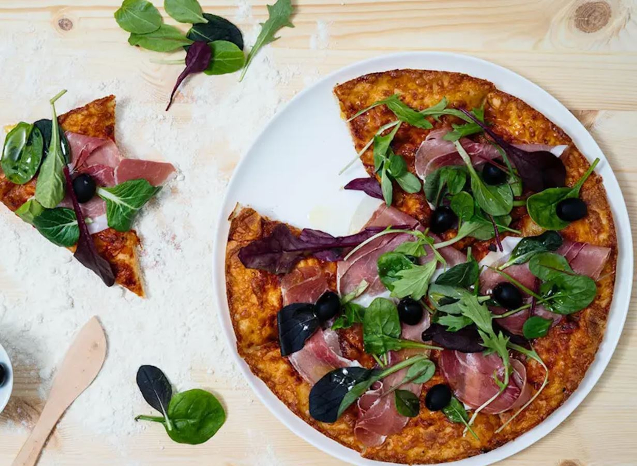 Pizzatallrikar med pizza på träbord 