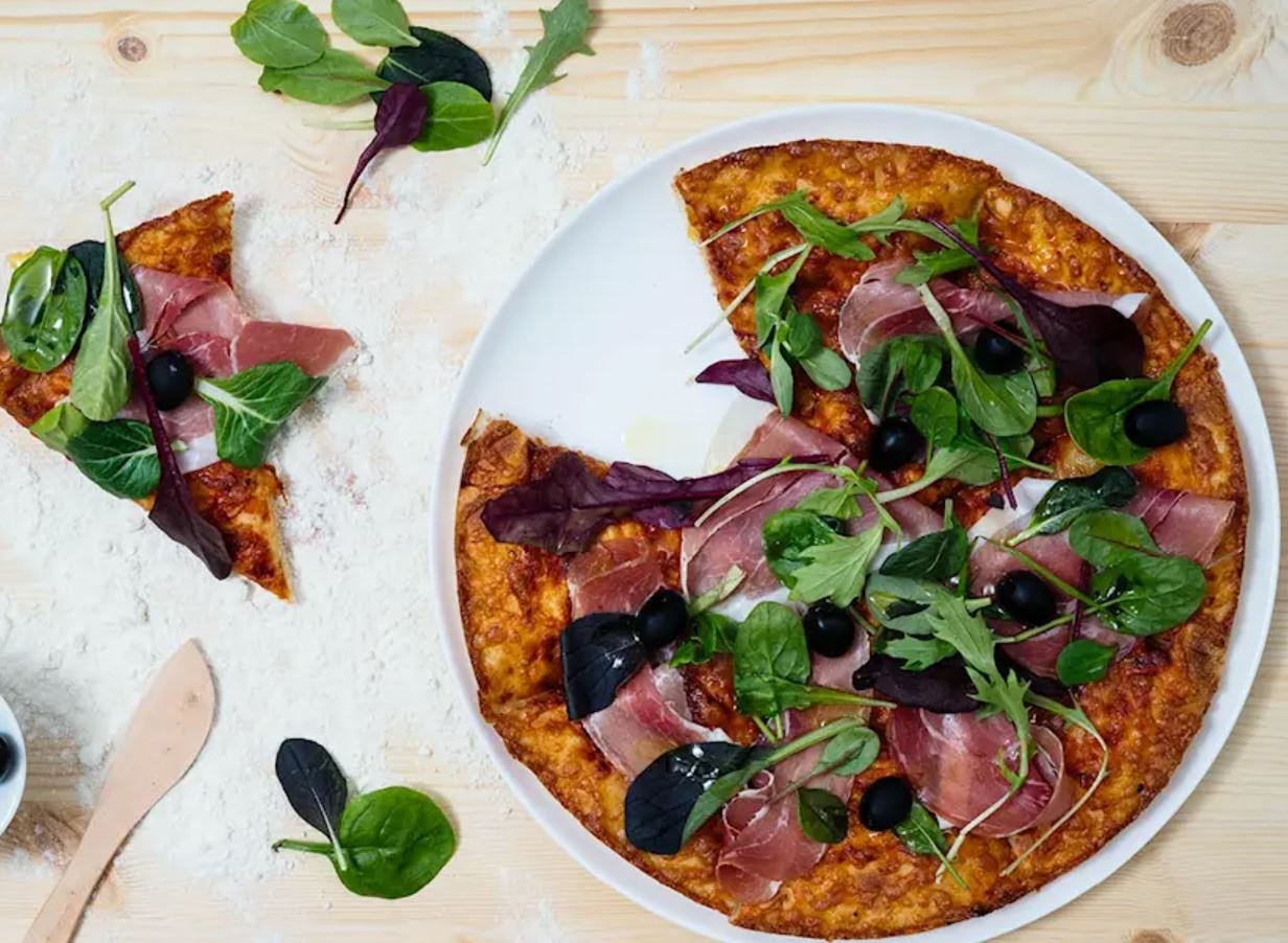 Pizzatallrikar med pizza på träbord