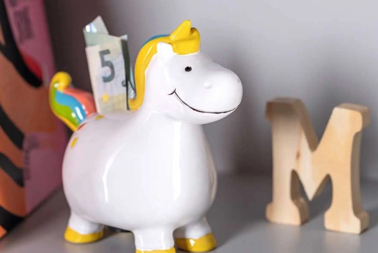 Sparbössor form av en hörning på rum med ett M i trä bredvid 