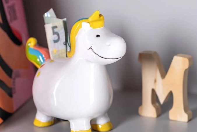 Sparbössor form av en hörning på rum med ett M i trä bredvid