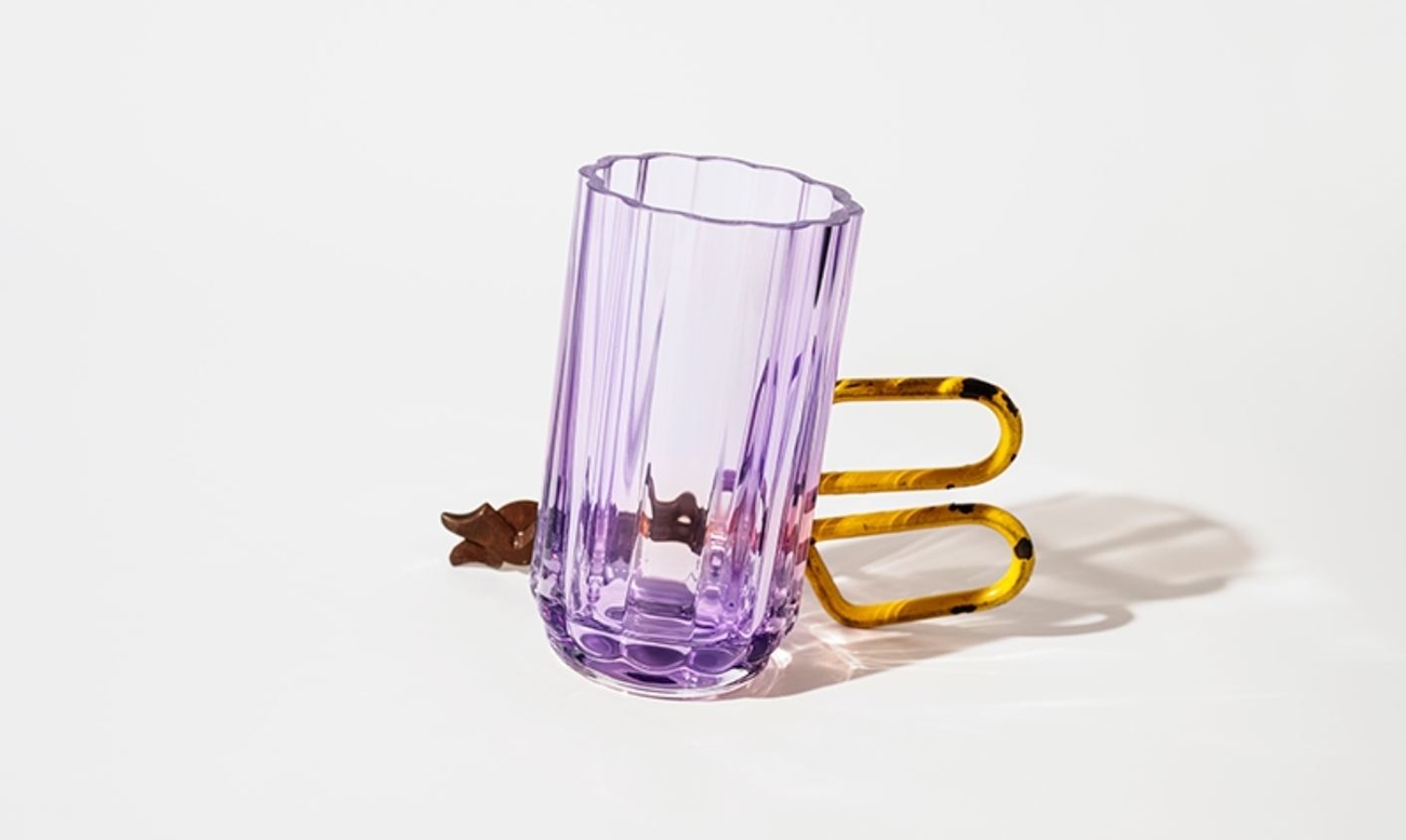 A ribbed purple glass with a tortoiseshell handle on a white background.