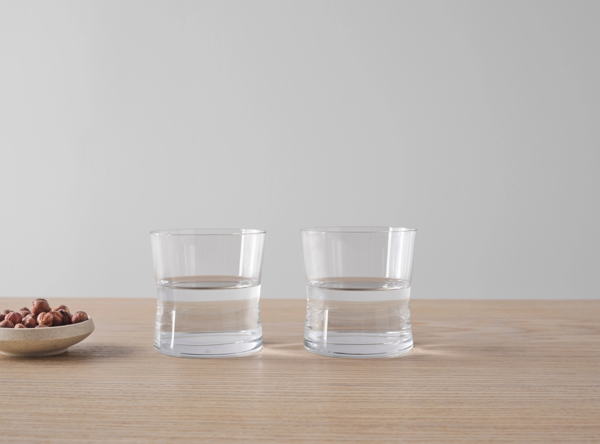 Tumblerglass i stilrent design på bord i lyst tre