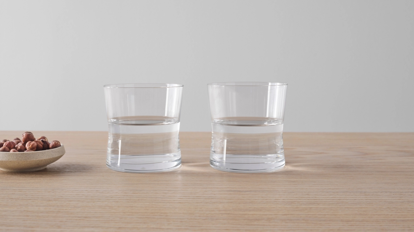 Tumblerglass i stilrent design på bord i lyst tre