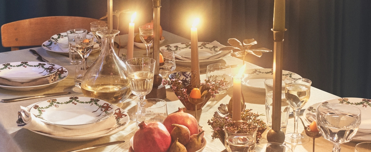 ett dukat bord för en middagsbjudning med ljus och tallrikar.