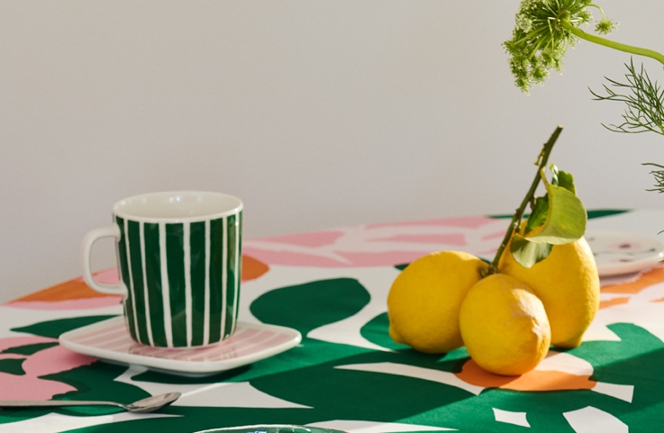 Marimekko piccolo muki ja lautanen värikkäällä pöytäliinalla