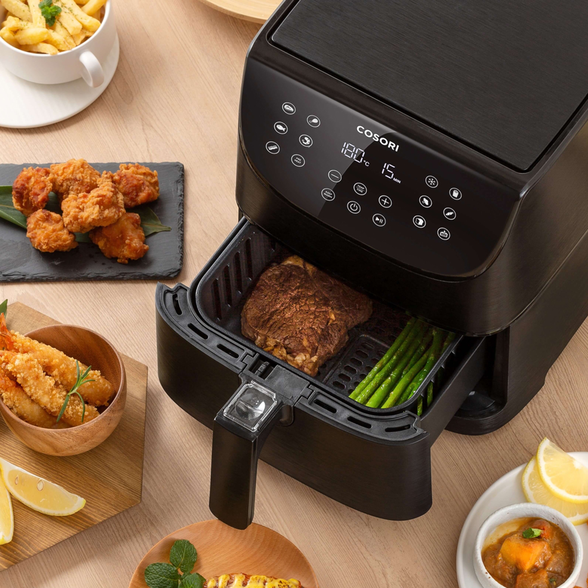 Bild som visar en airfryer med en köttbit och sparris