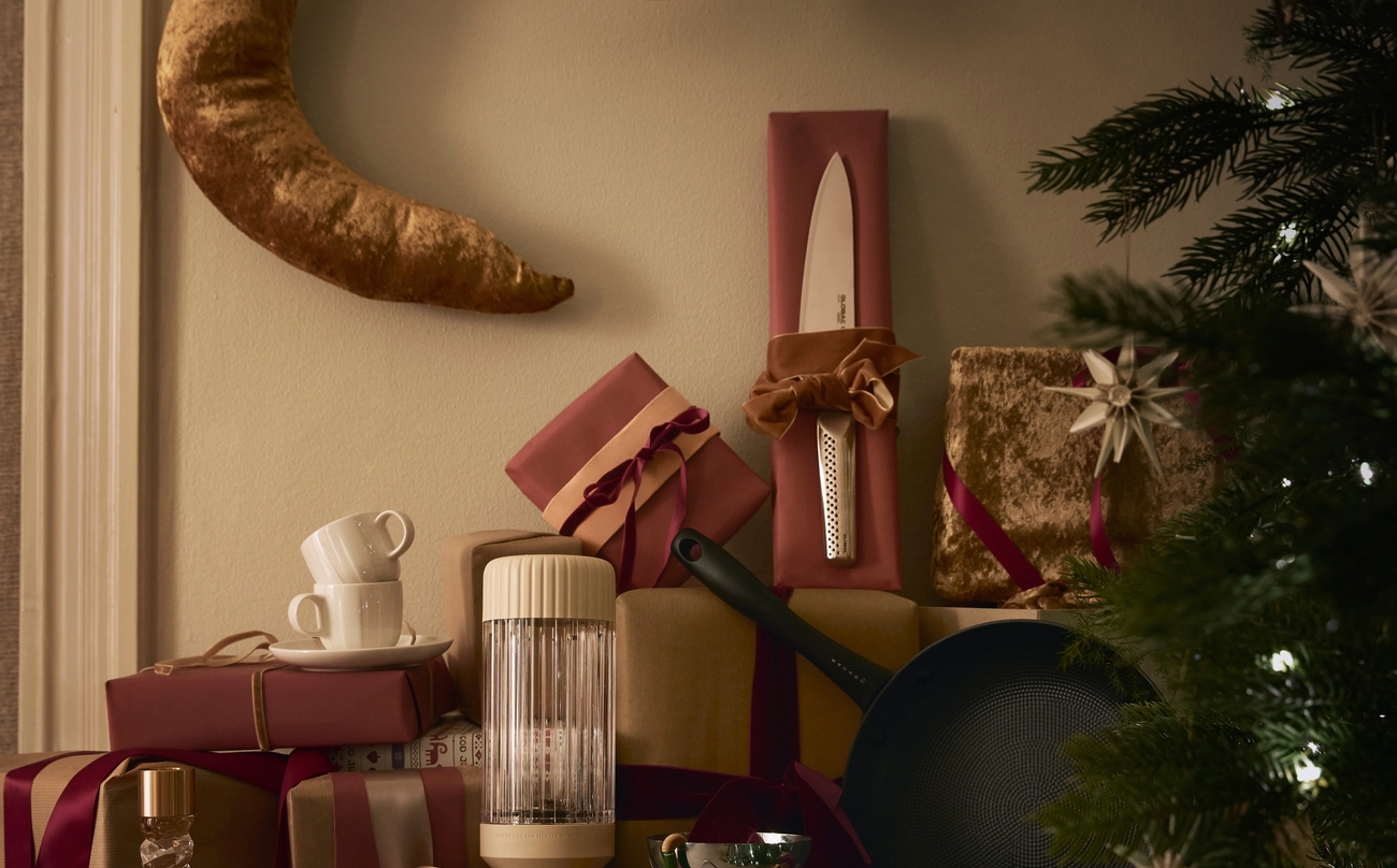 ett bord fyllt med julklappar och en julgran.