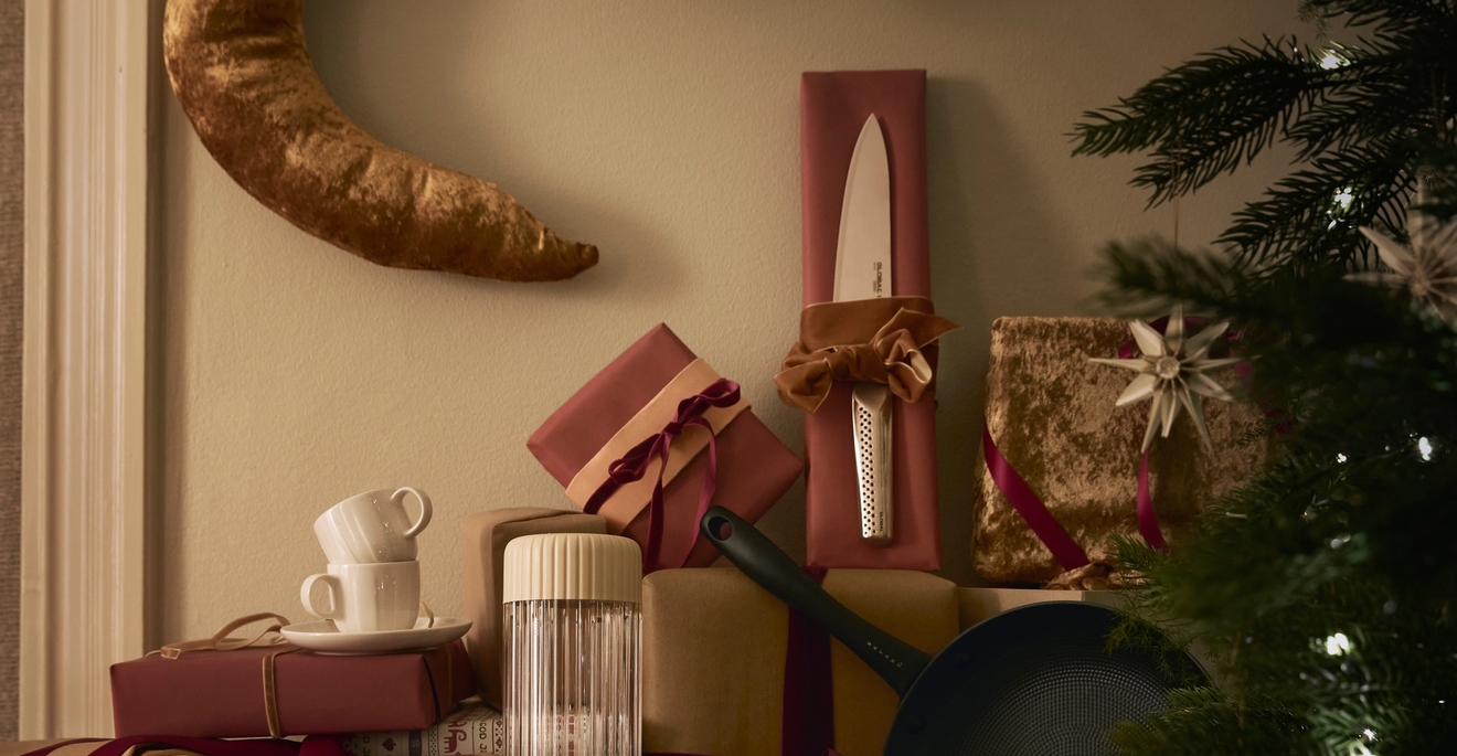 ett bord fyllt med julklappar och en julgran.