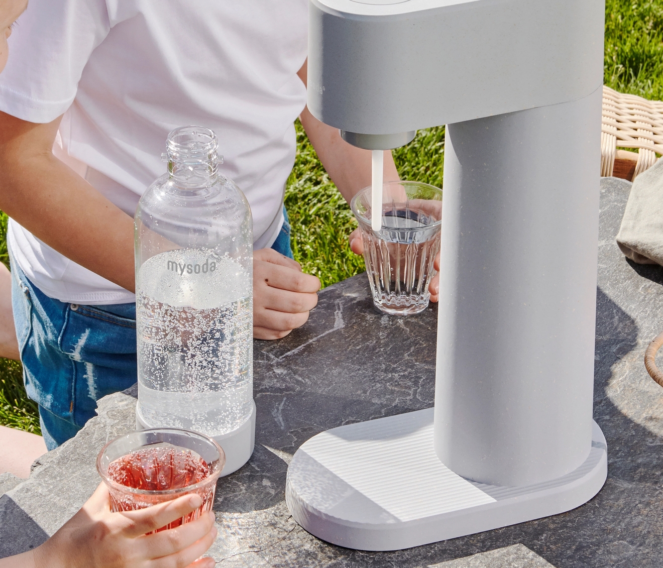 Mysoda woody hiilihapotuslaite ja muovinen pullo ulkona pöydällä