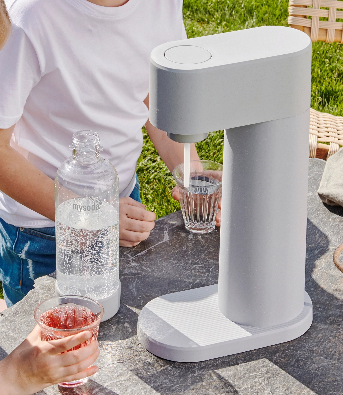 Mysoda woody hiilihapotuslaite ja muovinen pullo ulkona pöydällä