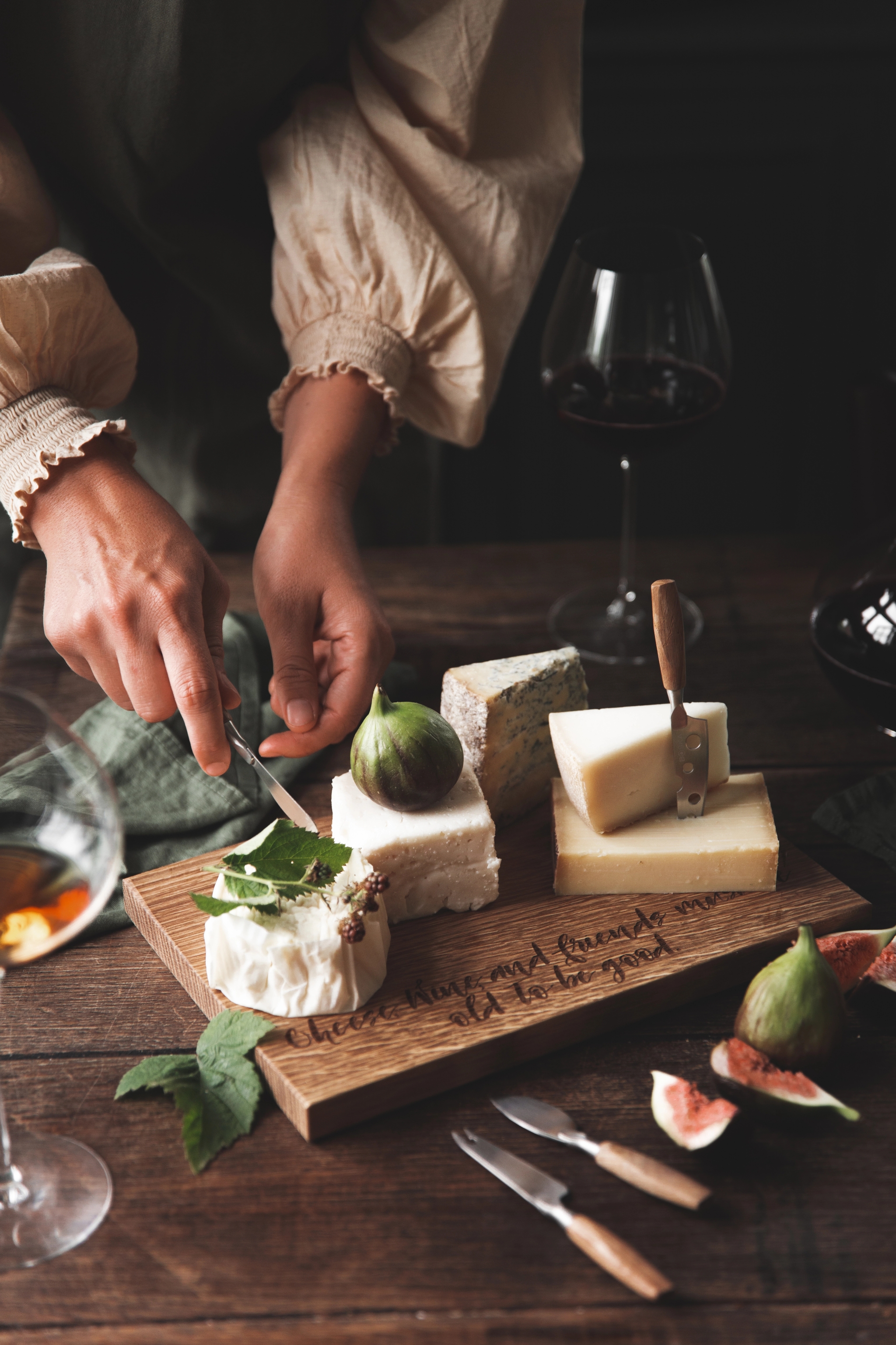 En person tar en bit ost från en ostbricka